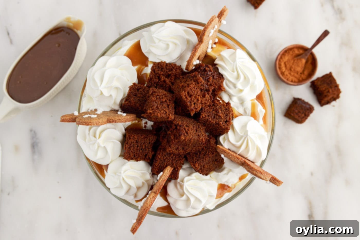 Beautifully garnished Gingerbread Trifle topped with gingerbread men cookies, whipped cream swirls, and a dusting of cinnamon, ready for serving.