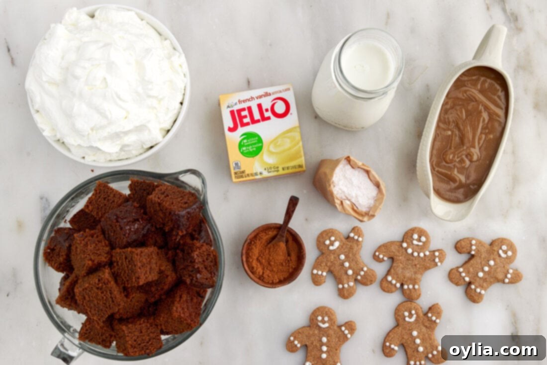 Arrangement of ingredients for Gingerbread Trifle, including milk, instant pudding mix, heavy cream, gingerbread cake, and caramel sauce.
