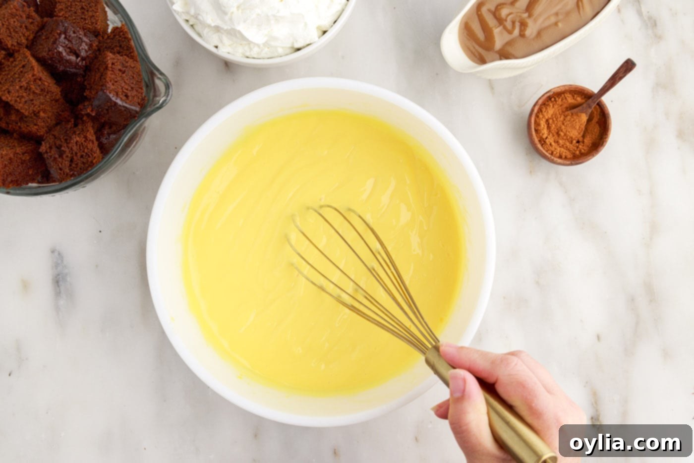 Whisking instant French vanilla pudding and milk together in a mixing bowl until it thickens.