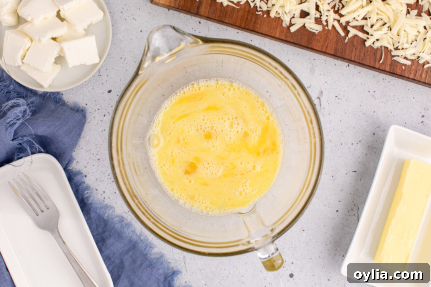 whisked eggs in a bowl, showing the light yellow color and minimal froth after being lightly beaten, ready for other ingredients.