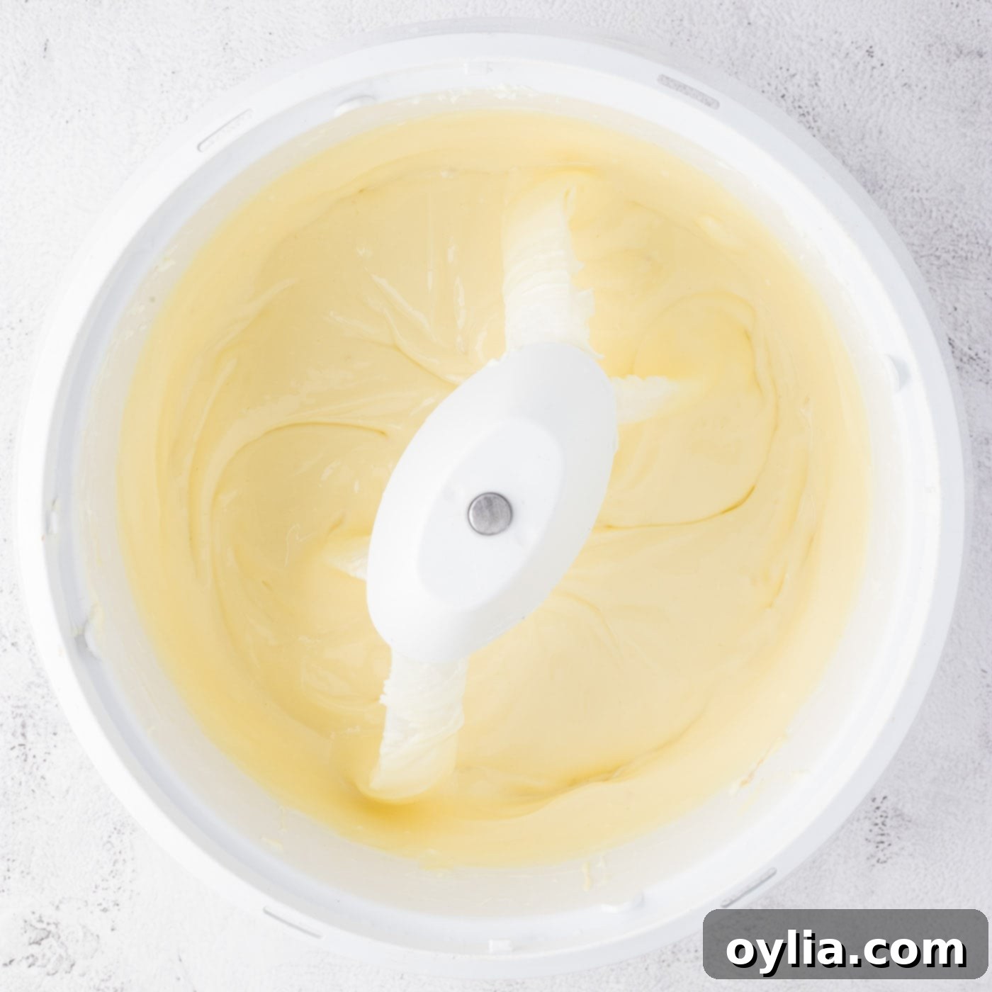 Smooth cheesecake batter in a mixer bowl, ready for assembly.