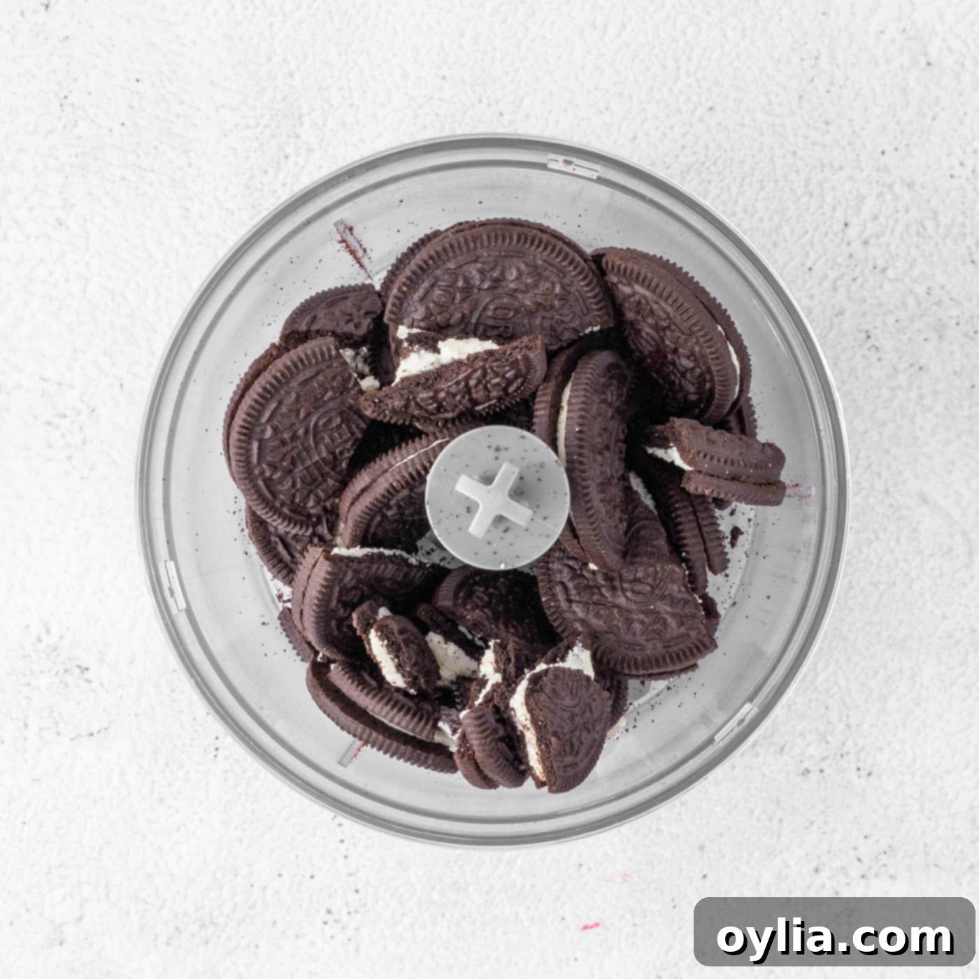 Crushing Oreo cookies in a food processor to make crumbs for the crust.