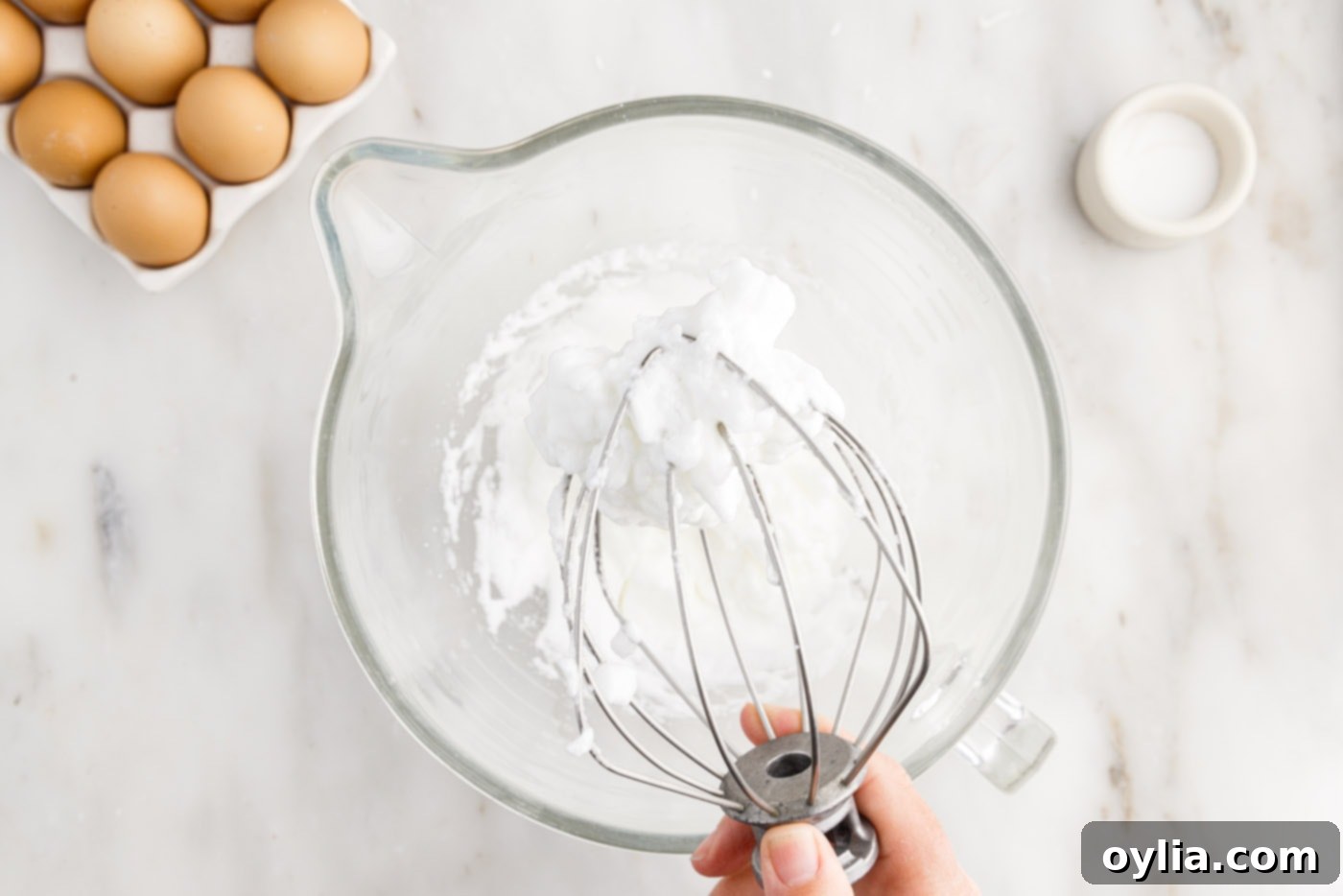 Whipped egg whites with stiff peaks in a stand mixer bowl