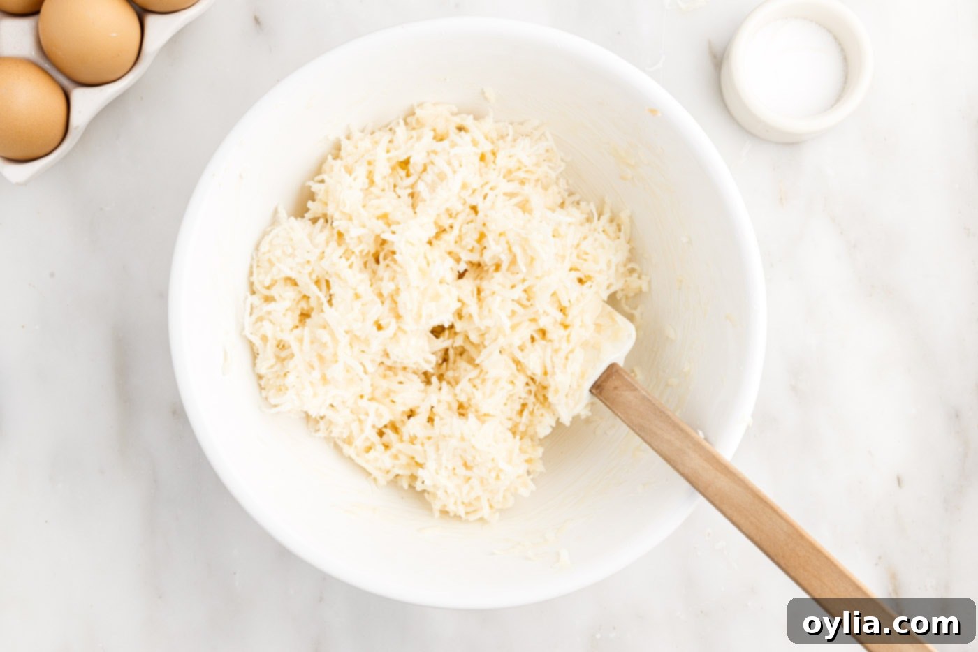 Shredded coconut and sweetened condensed milk mixture in a bowl after mixing