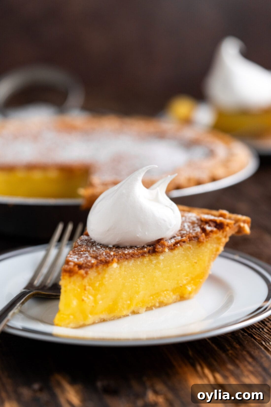 Slice of Chess Pie on a plate topped with whipped cream