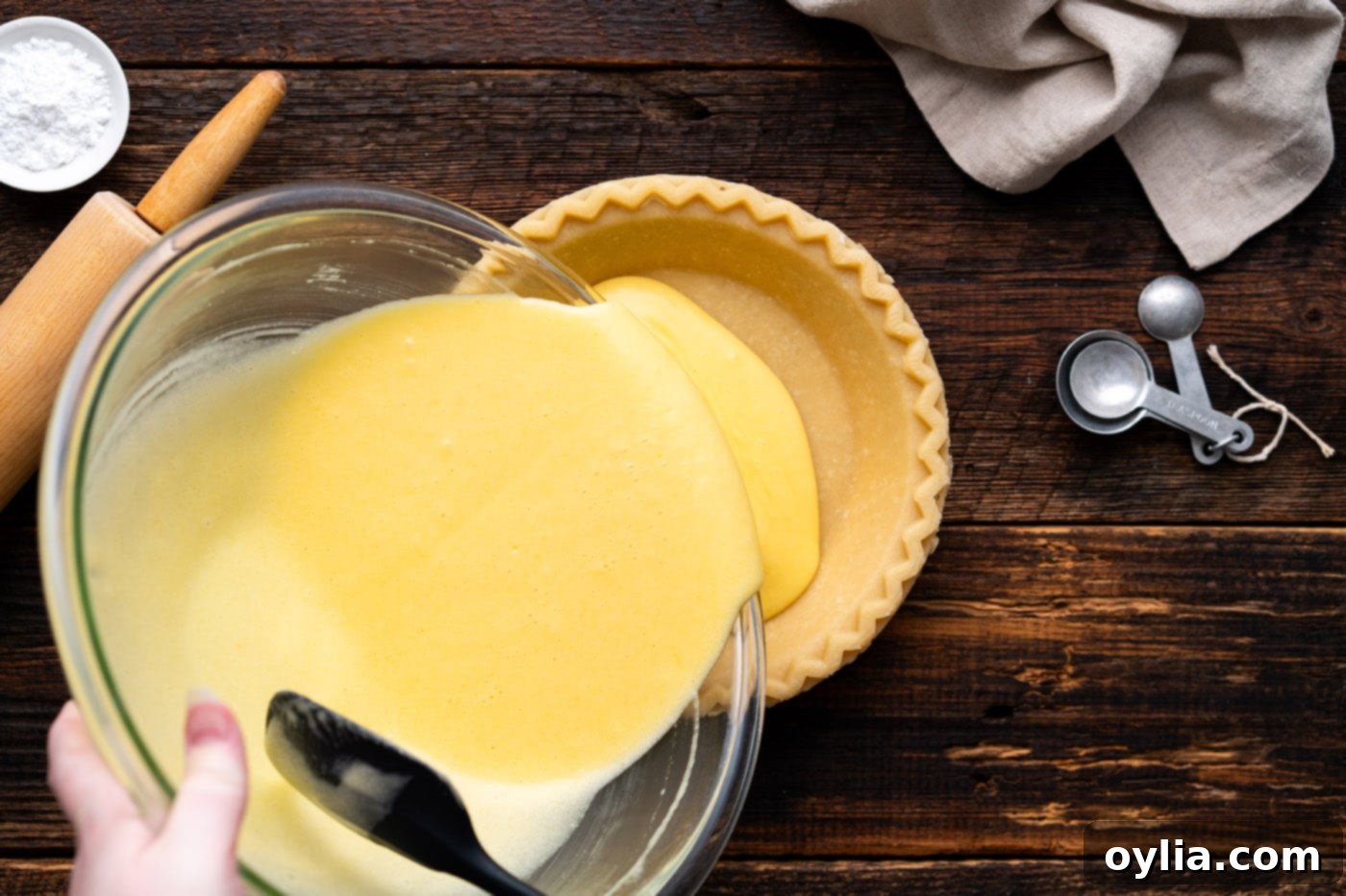 pouring chess pie filling into a pie crust