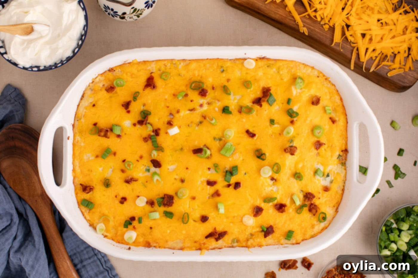 Twice Baked Potato Casserole topped with crumbled bacon and fresh green onions, ready to serve.