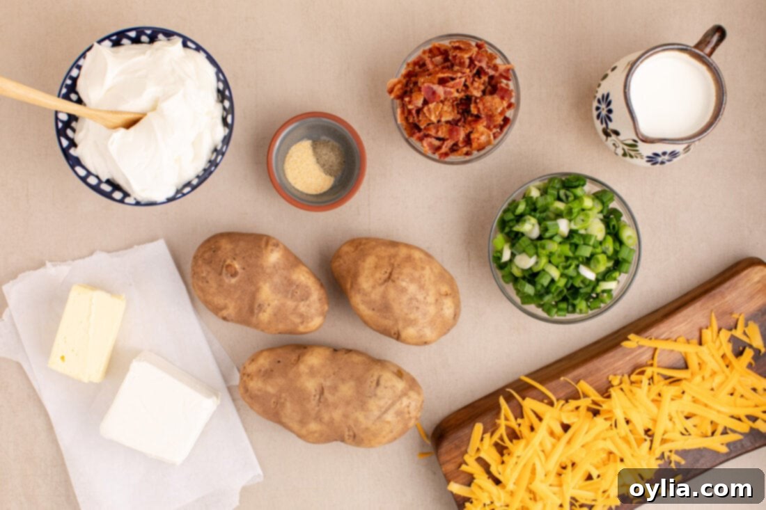 Ultimate Cheesy Potato Bake 4 Ingredients for Twice Baked Potato Casserole laid out on a counter, including potatoes, cheeses, sour cream, milk, butter, bacon, and green onions.