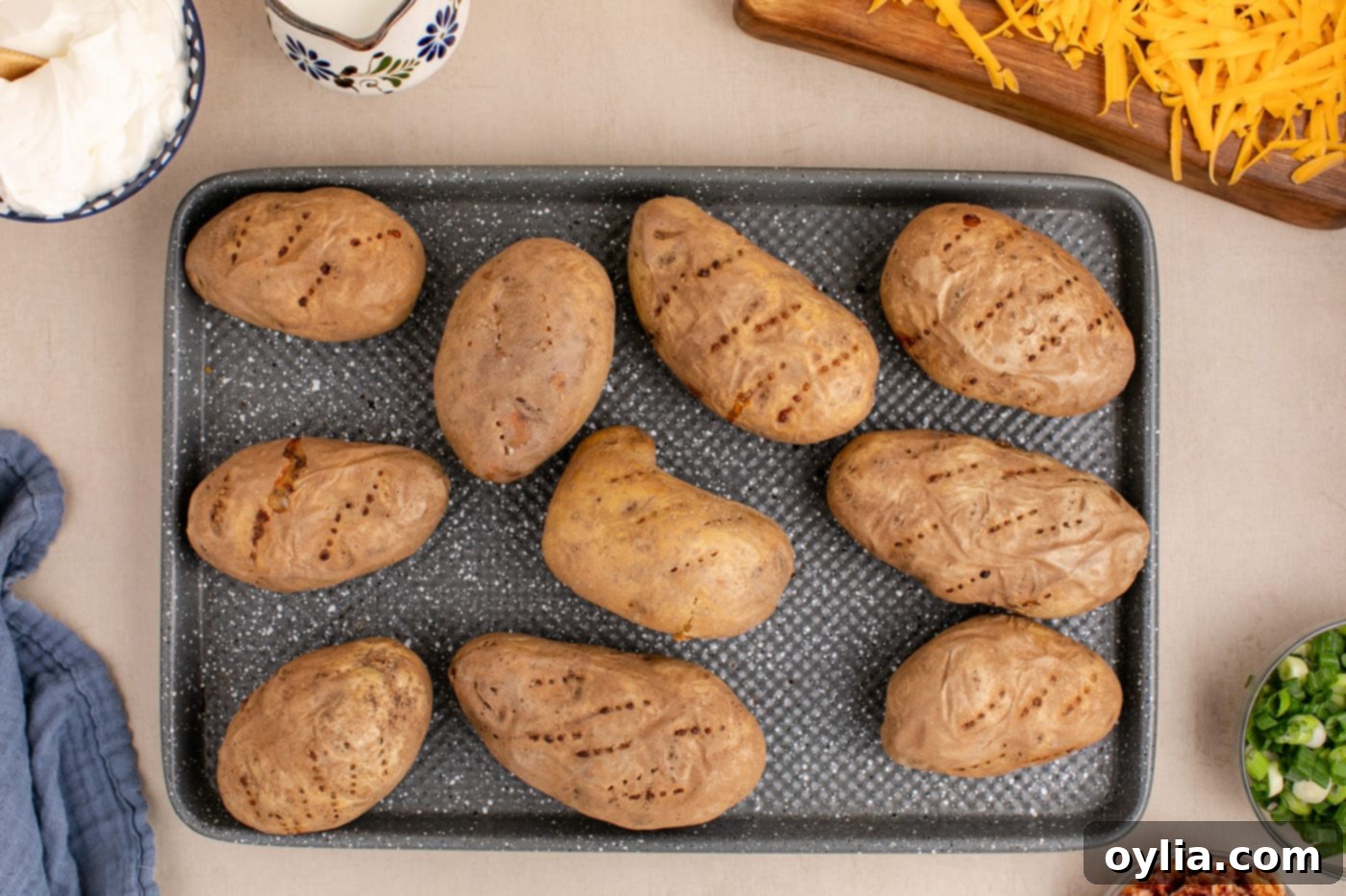 Freshly baked russet potatoes on a baking sheet, golden and tender.