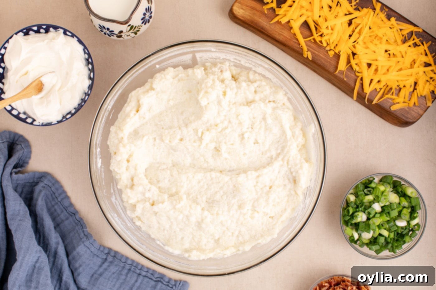 Creamy twice baked potato filling in a bowl after mixing with dairy and seasonings.