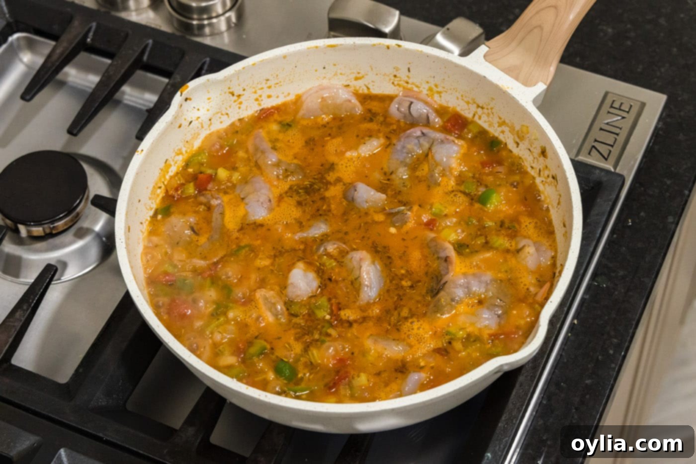 cooking shrimp into tomato sauce in a skillet