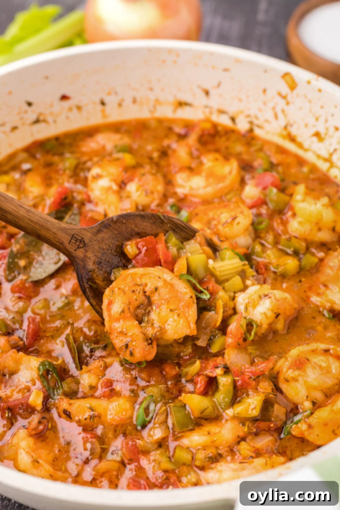Close up photo of a spoonful of Shrimp Creole in a skillet
