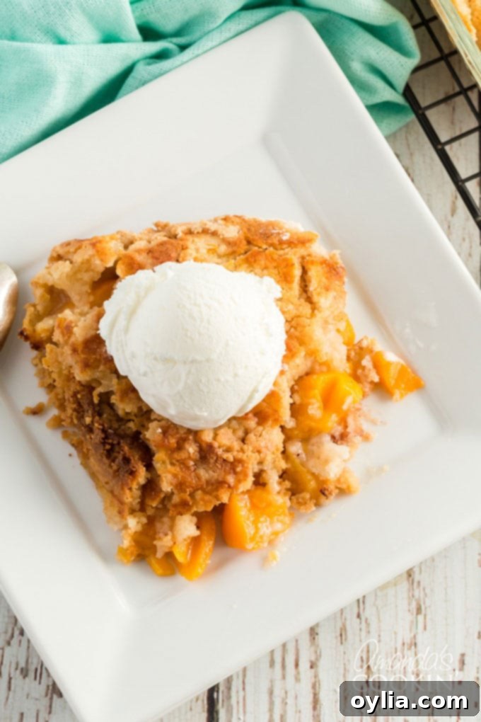 Overhead view of a freshly baked peach dump cake, served with scoops of vanilla ice cream, creating a perfect dessert ensemble.