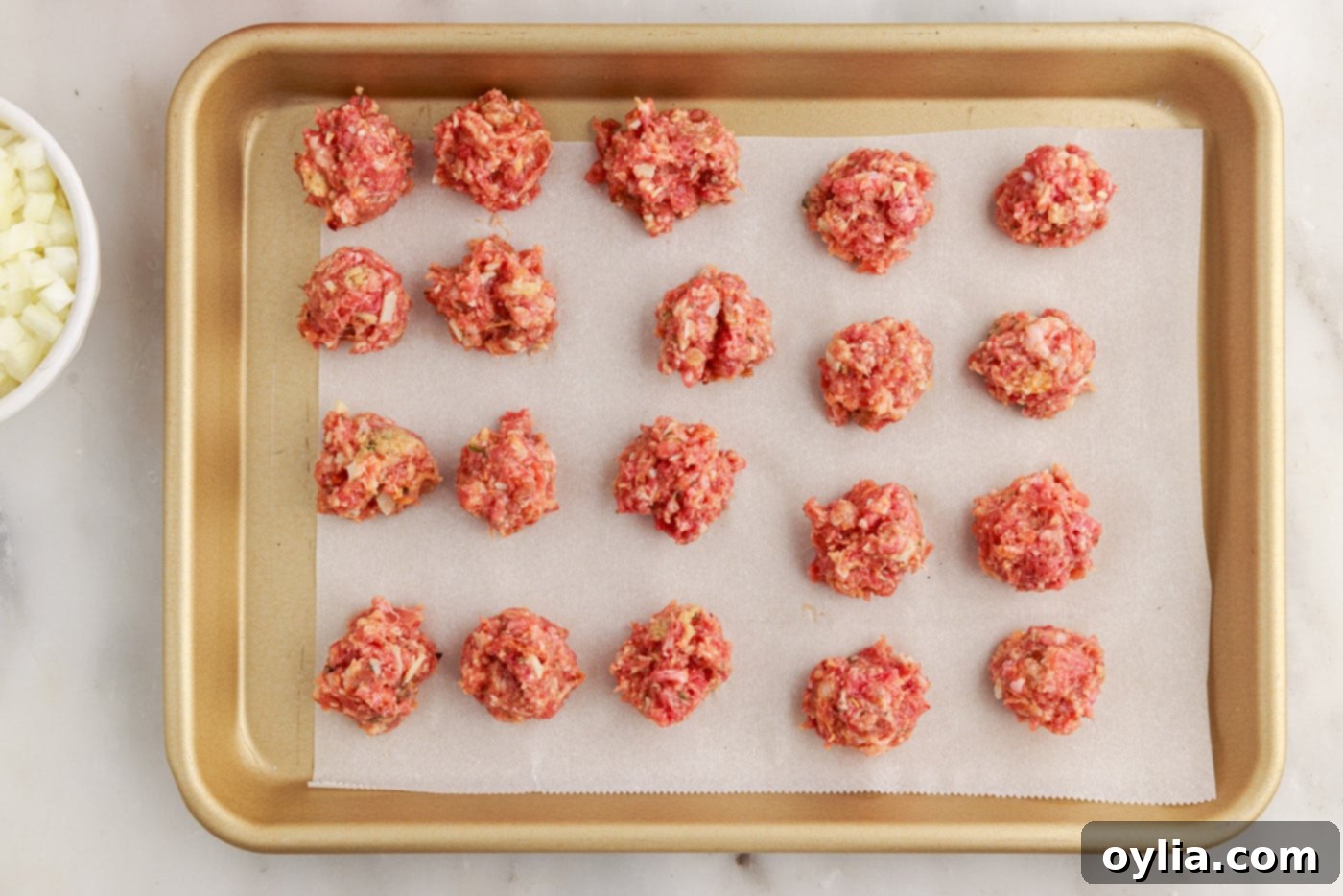 Italian sausage and ground beef meatballs on a baking sheet
