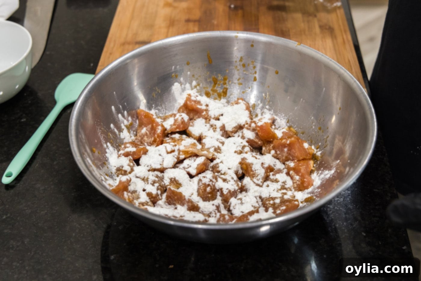 Marinated pork cubes with flour sprinkled on top, ready for breading