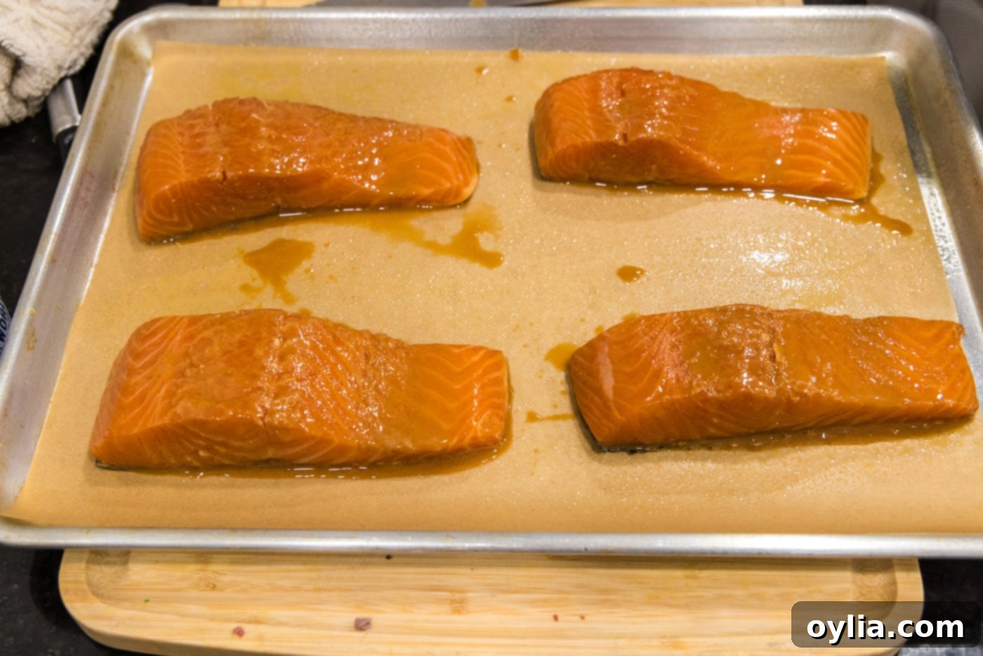 Miso salmon fillets arranged skin side down on a parchment-lined baking sheet