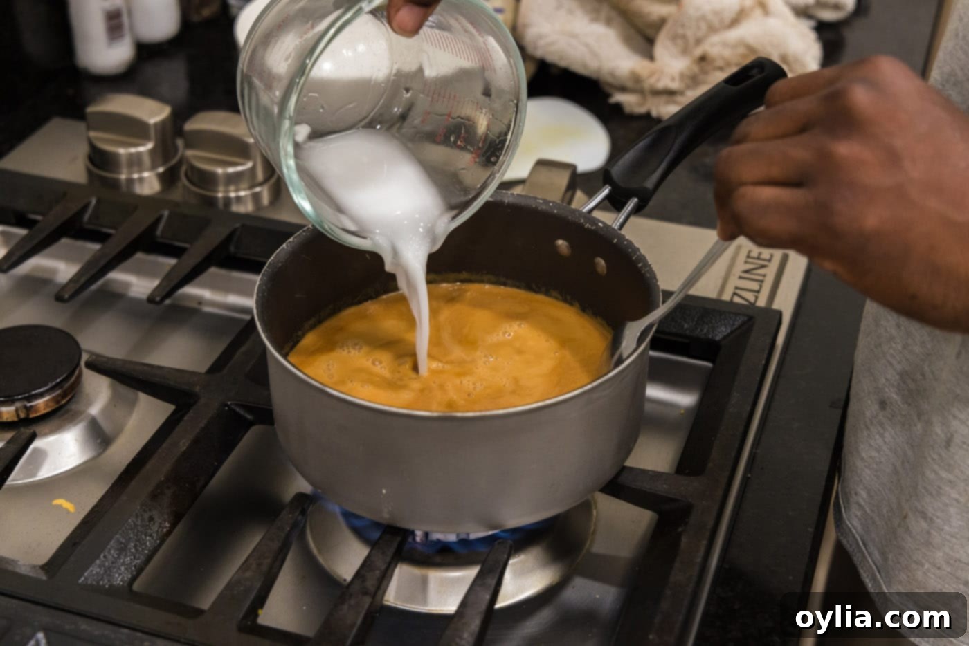 Adding cornstarch slurry to the miso glaze in a saucepan to thicken it