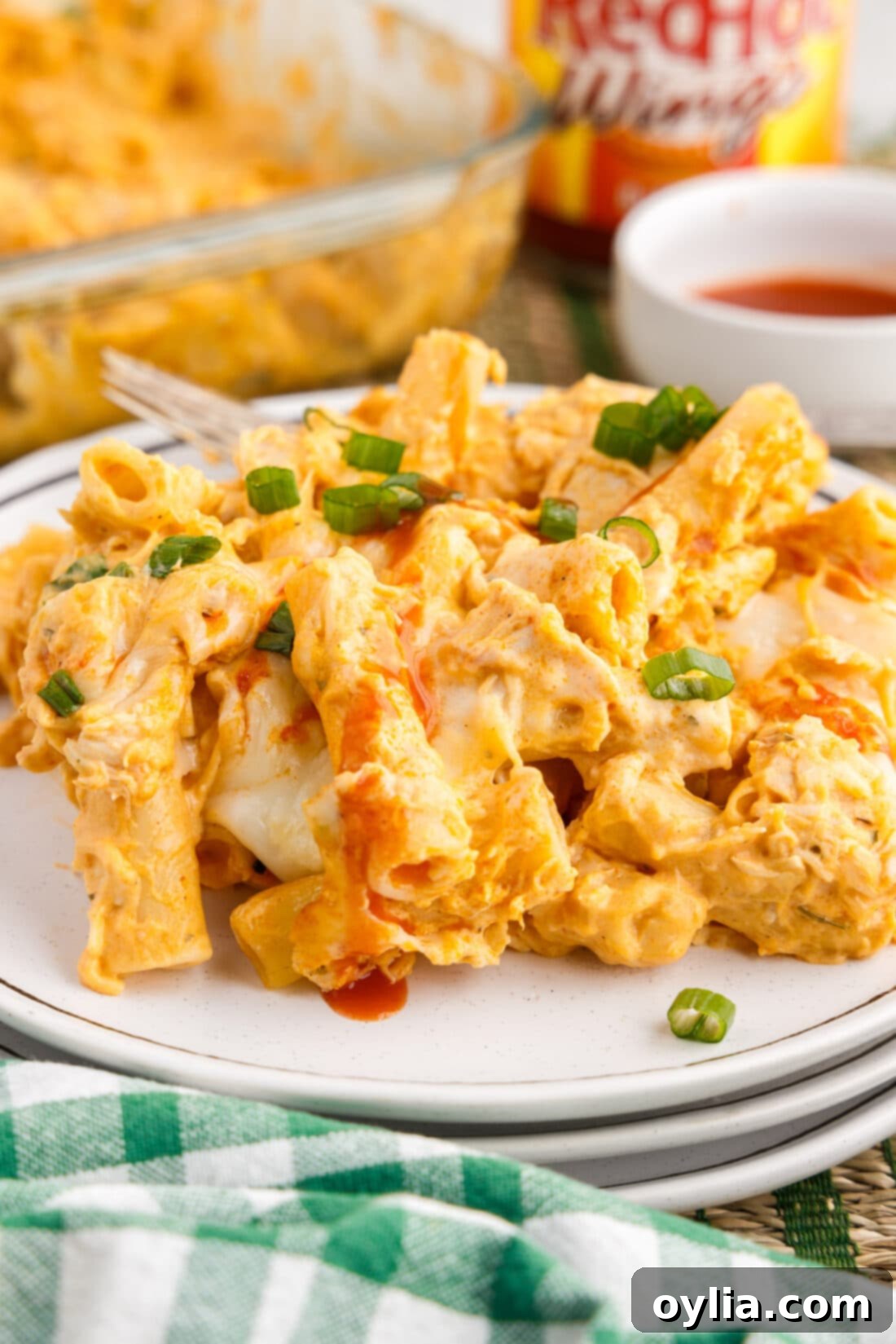 A single serving of the hot and cheesy Buffalo Chicken Casserole on a plate, garnished with green onions.