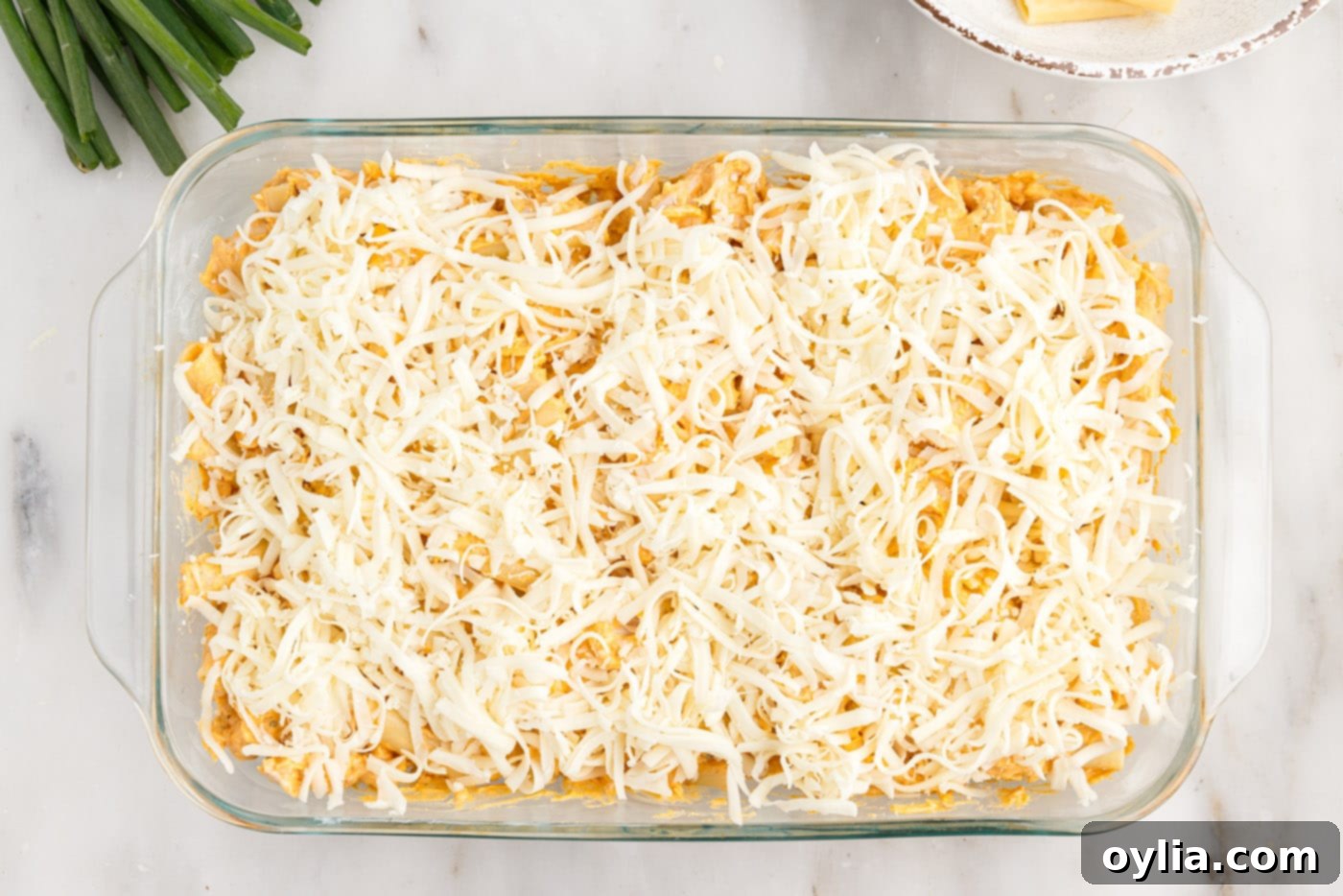 The top of the buffalo chicken casserole covered with a generous layer of shredded mozzarella cheese.