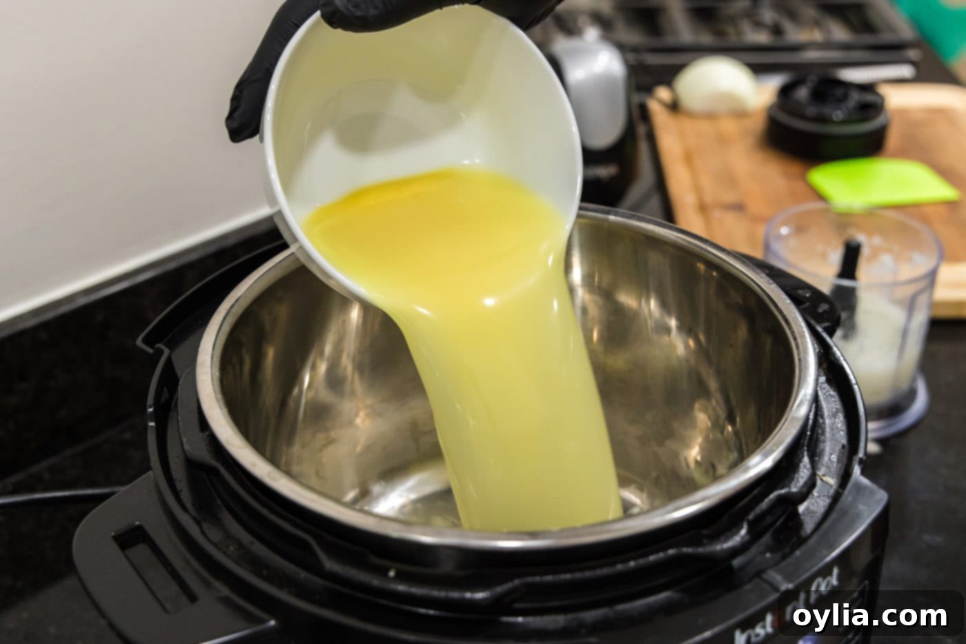 Pouring chicken stock into Instant Pot