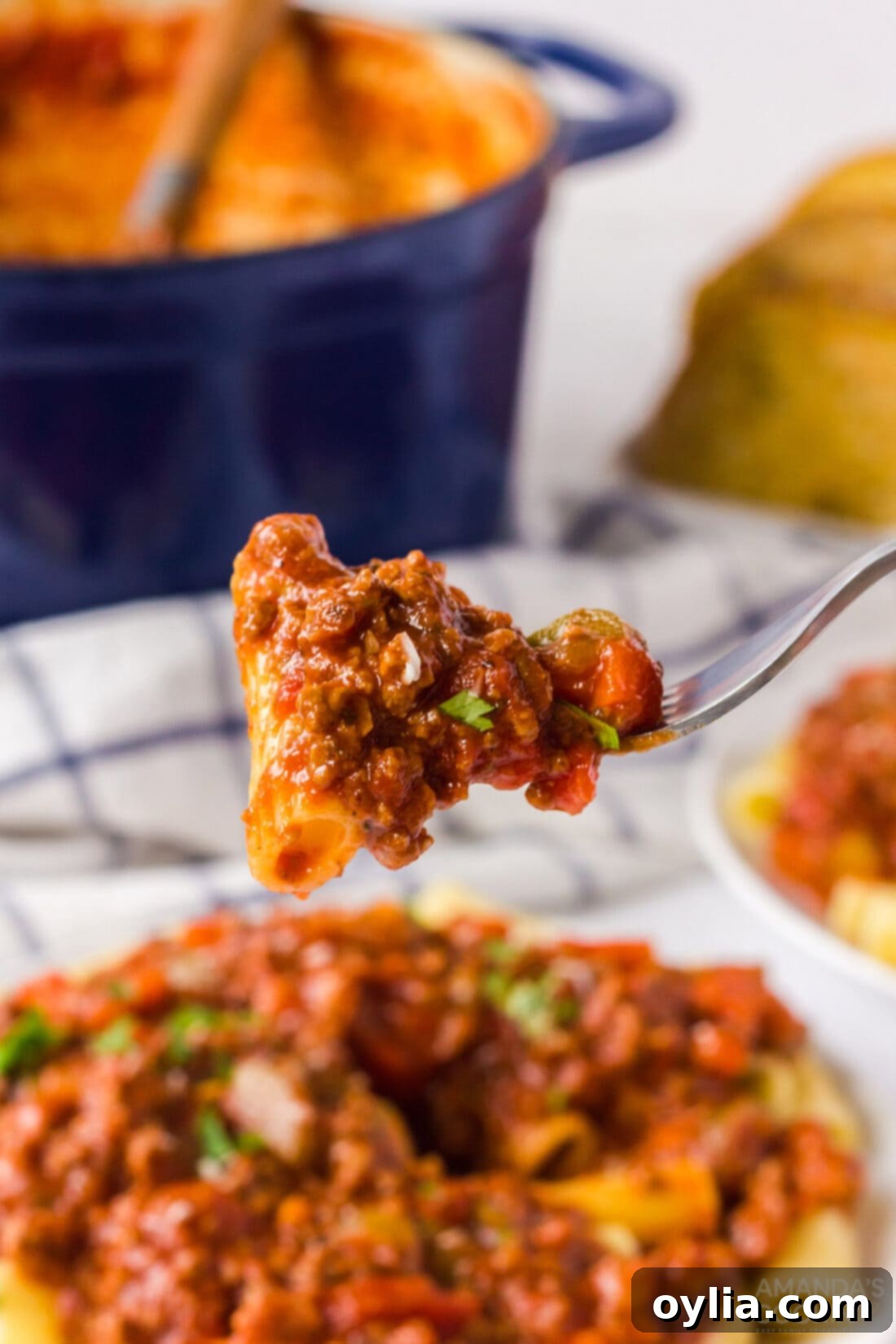 close up of a fork holding pasta with bolognese sauce