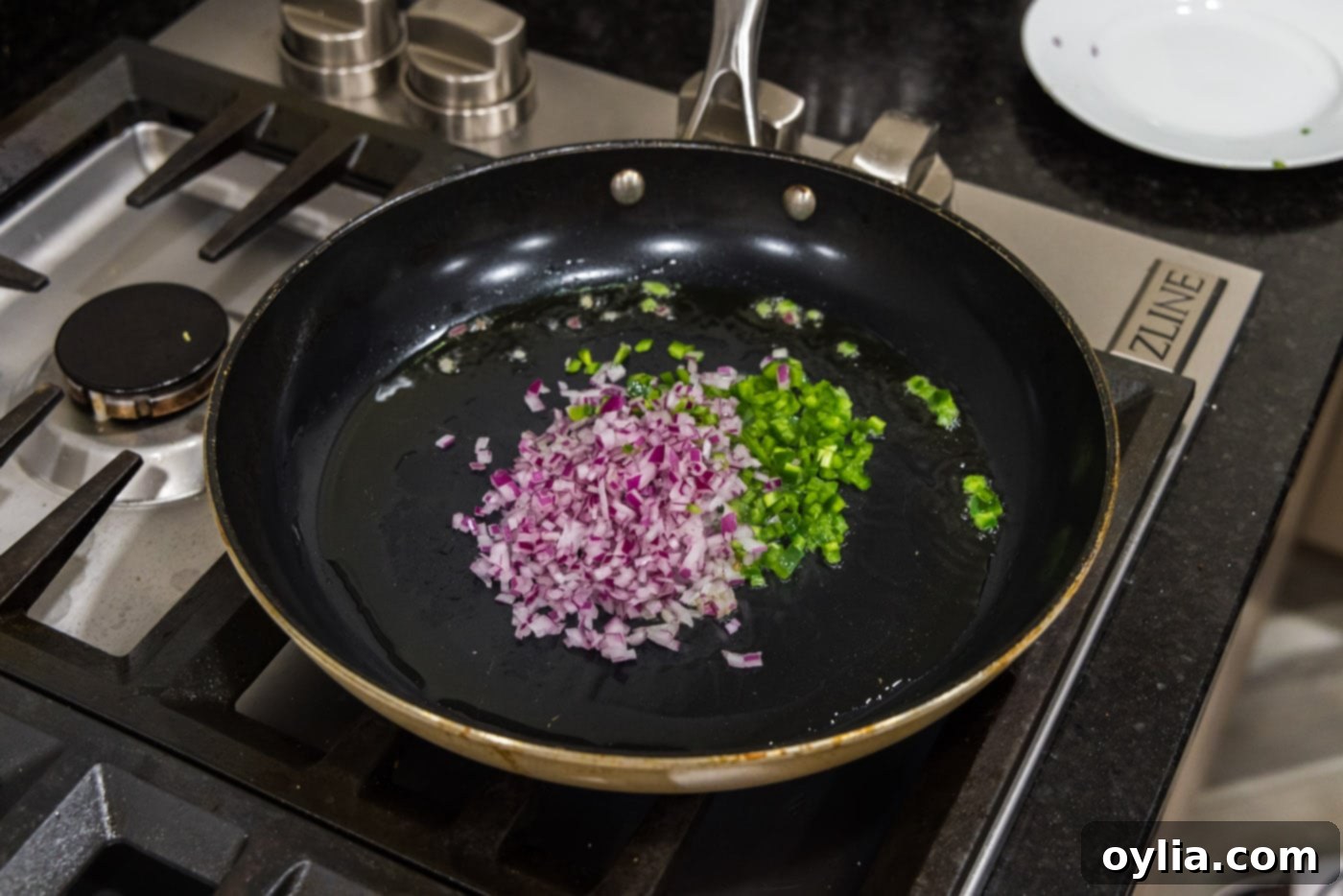 chopped onion and jalapeno peppers in a skillet with oil