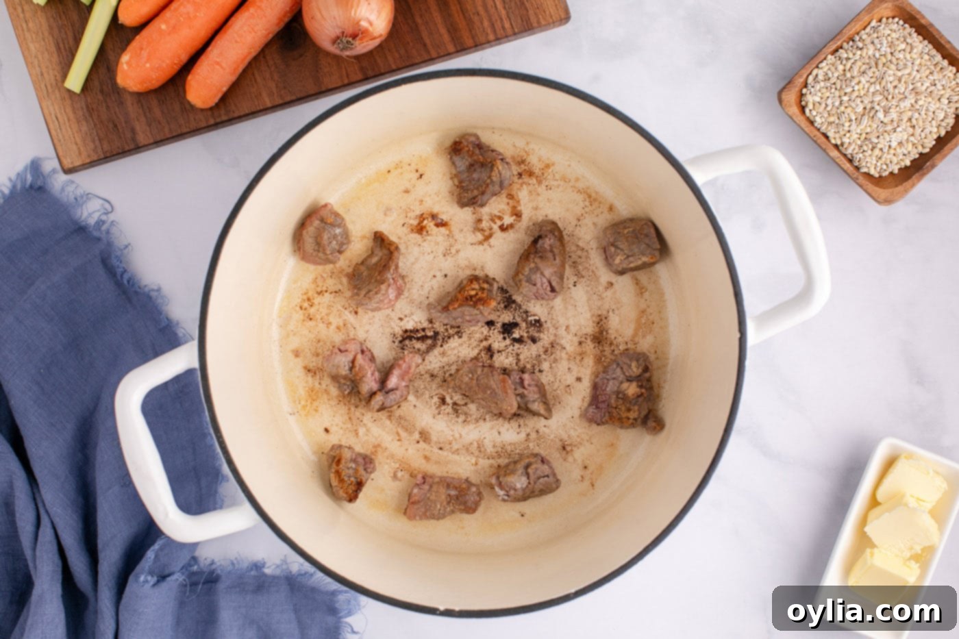 searing stew meat in a pot with butter