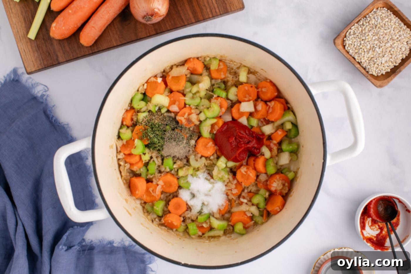herbs, spices, and tomato paste added to soup pot with vegetables