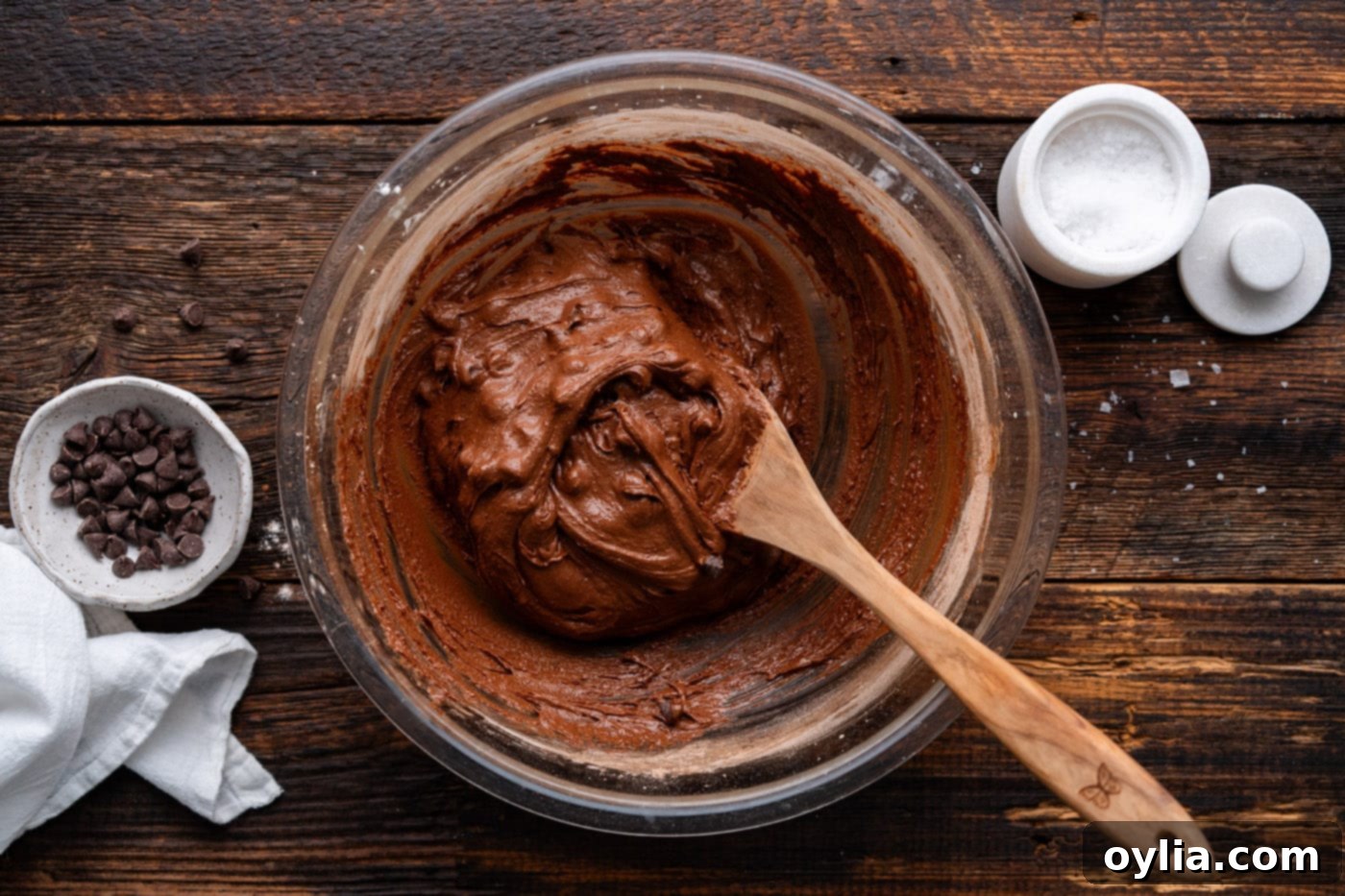 salted brownie cookie dough in a bowl with wooden spoon and chocolate chips visible