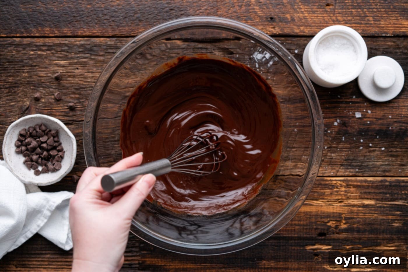 whisking together melted chocolate and butter in a bowl until smooth