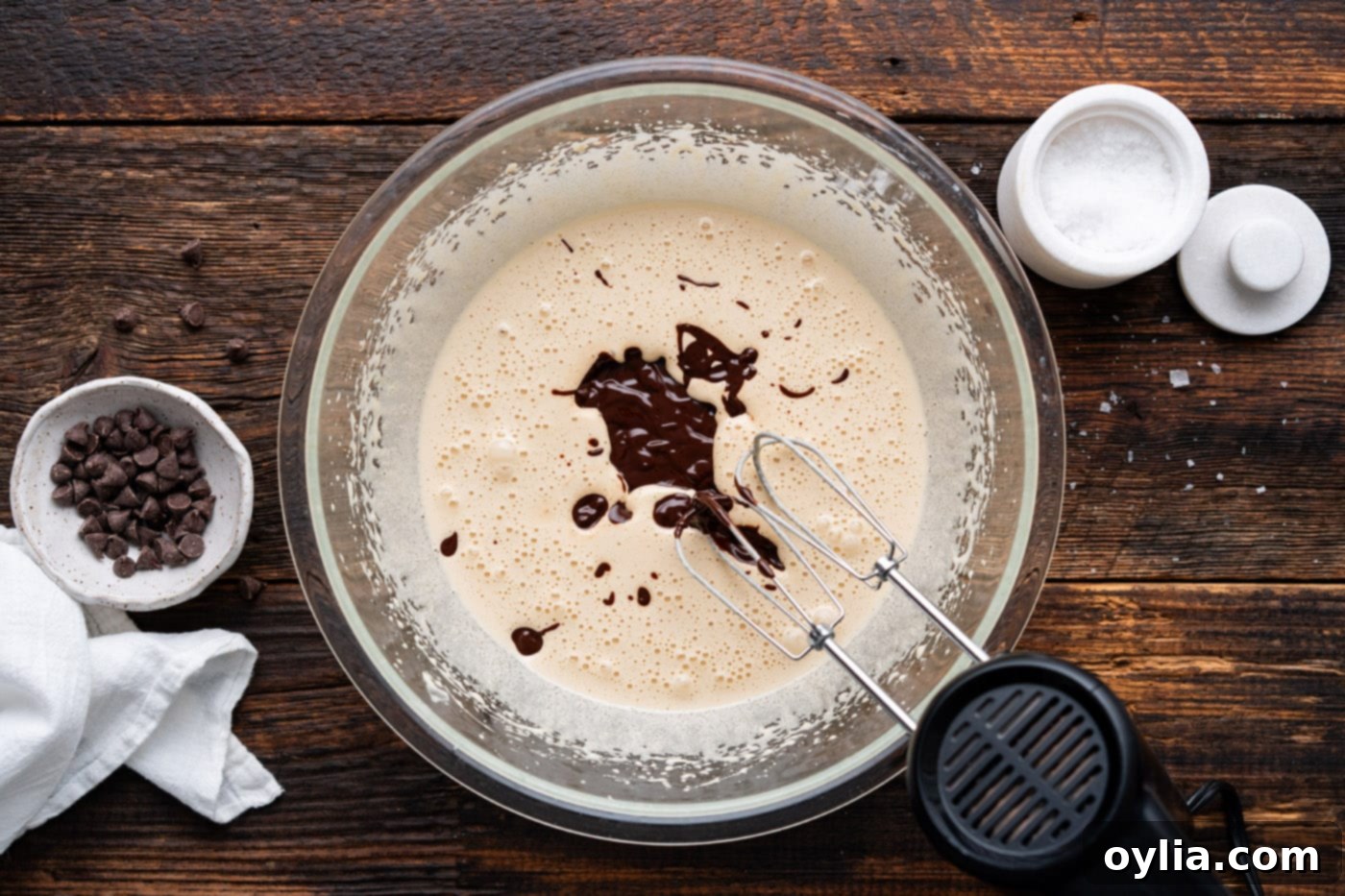 beating cookie dough mixture with a hand mixer after adding chocolate