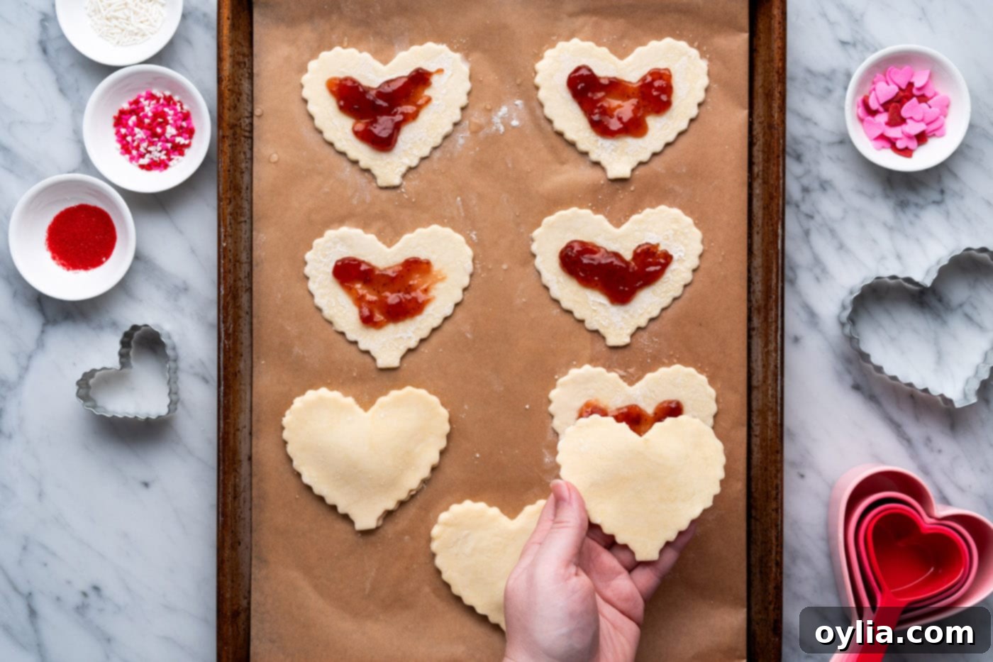 placing pie dough on top of jam filled crust
