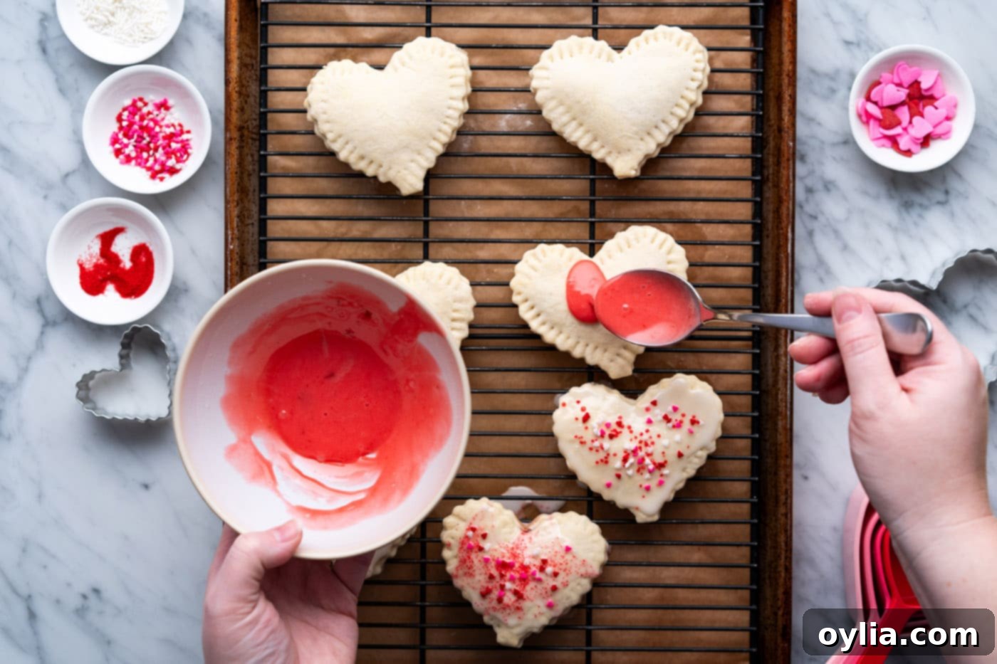 pouring red strawberry glaze over heart shaped pop tarts