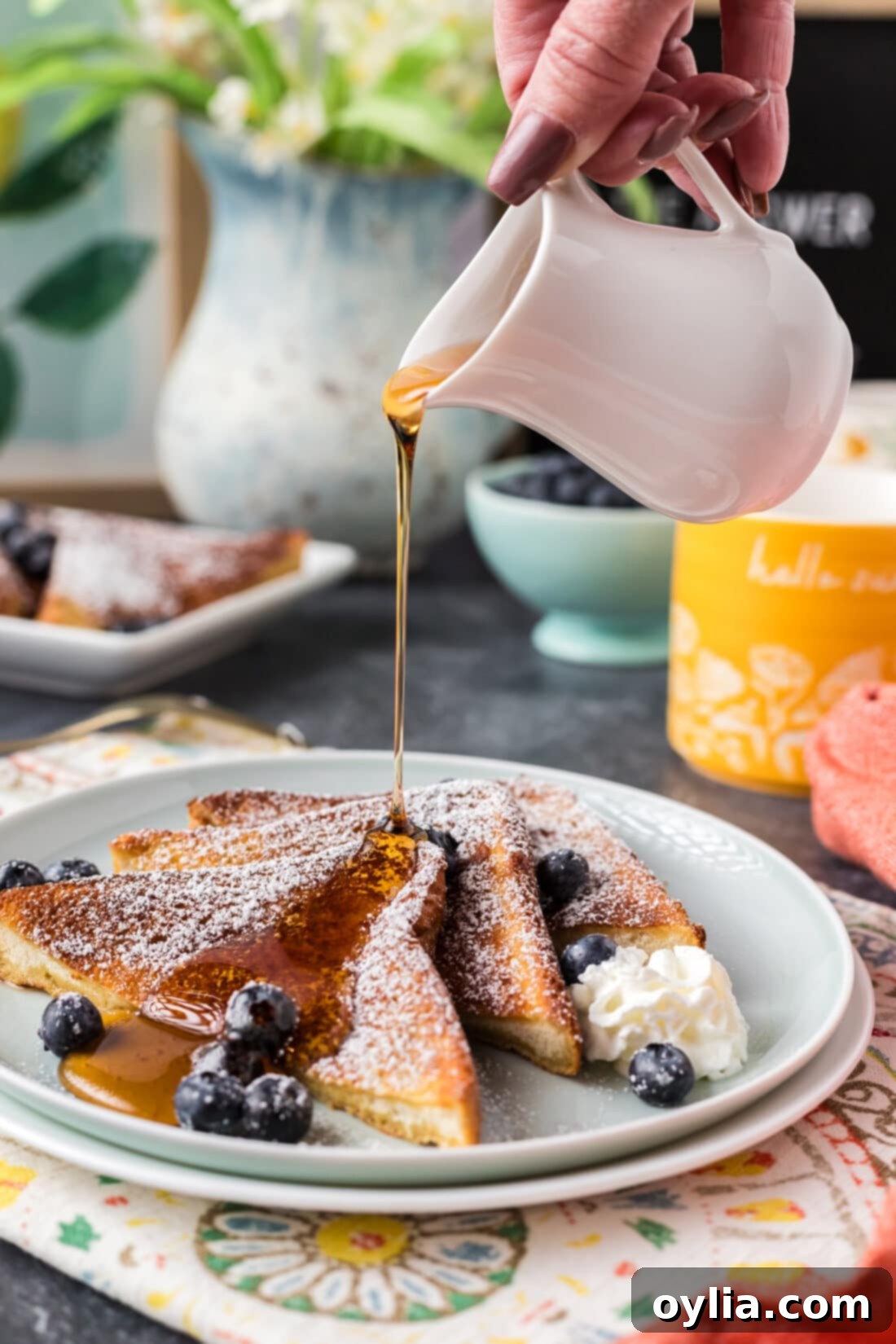 Syrup being drizzled over three slices of Air Fryer French Toast on a plate