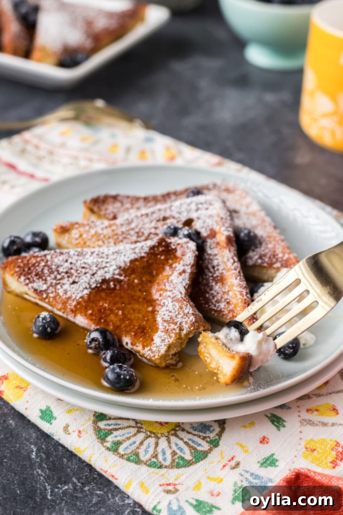 Piece of Air Fryer French Toast on a fork resting on a plate 