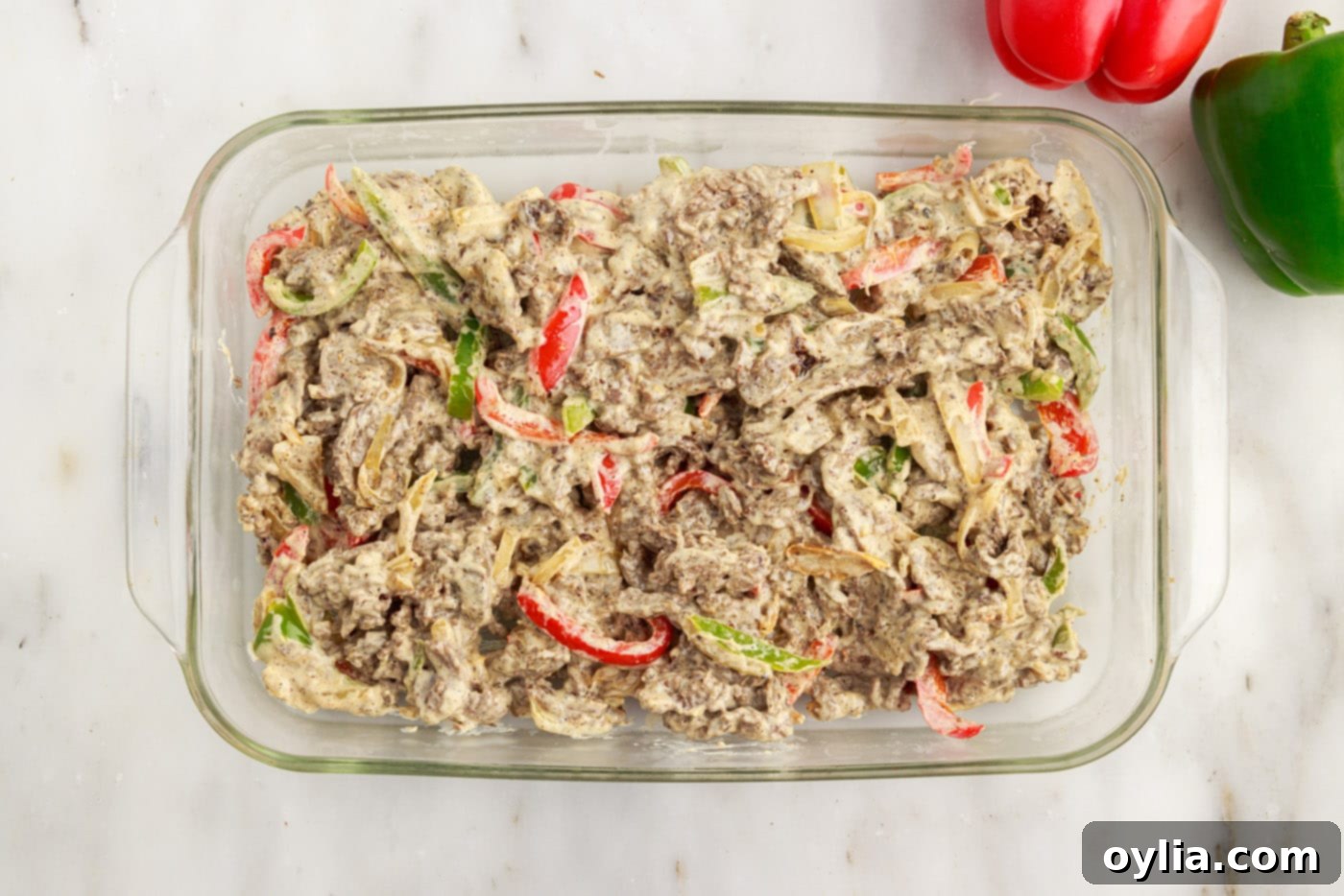 philly cheesesteak casserole ingredients in a baking dish