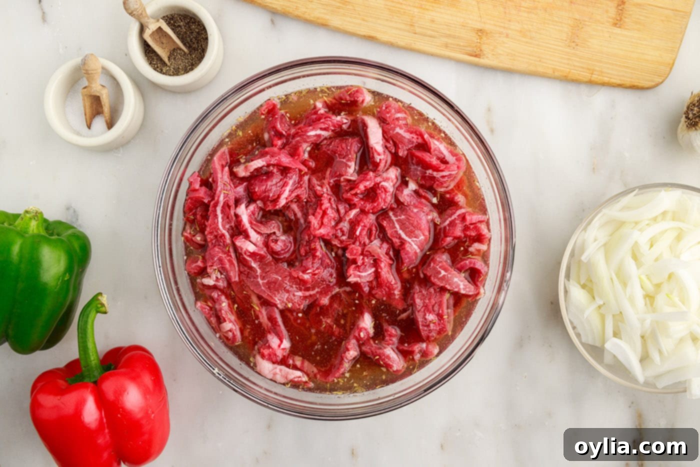 sliced flank steak in a bowl with marinade