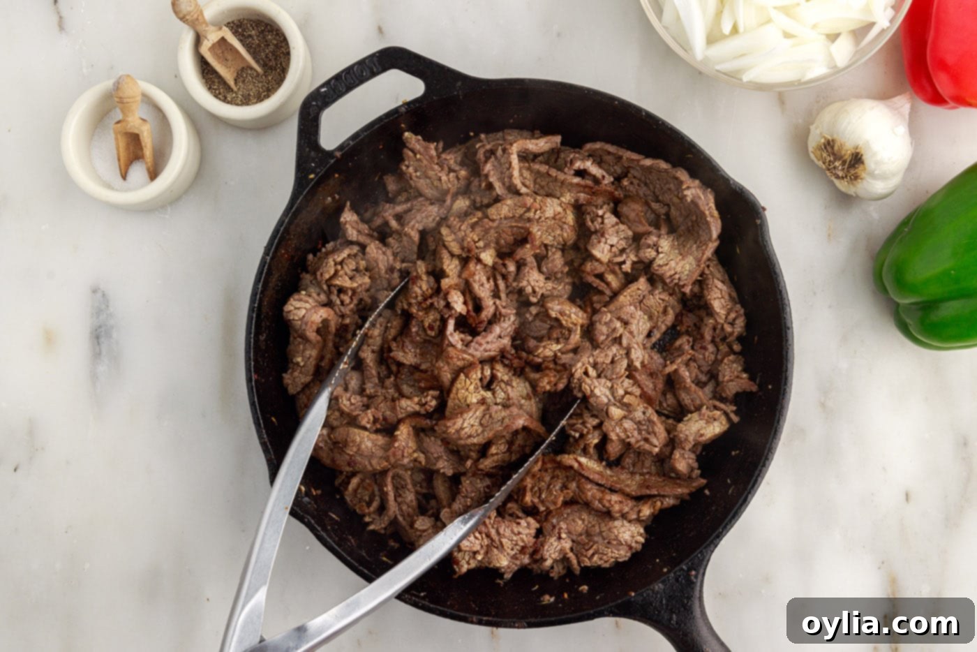 cooked flank steak slices in a cast iron skillet