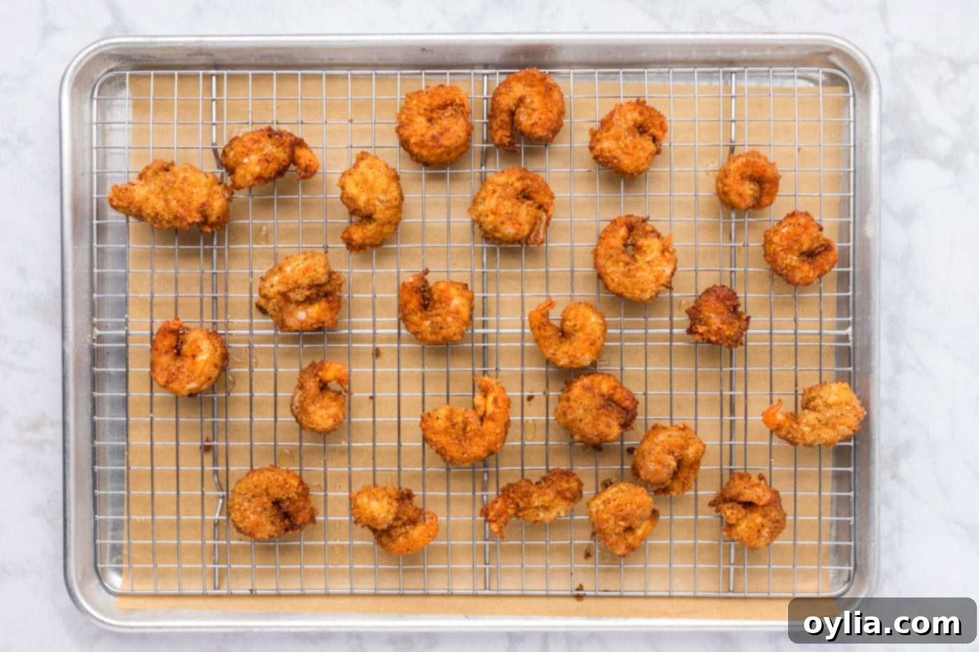 golden fried breaded shrimp on a baking sheet