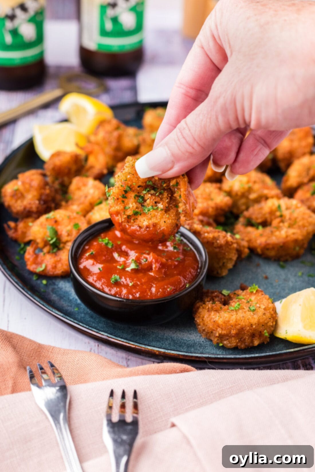 Breaded Shrimp being dipped in cocktail sauce 