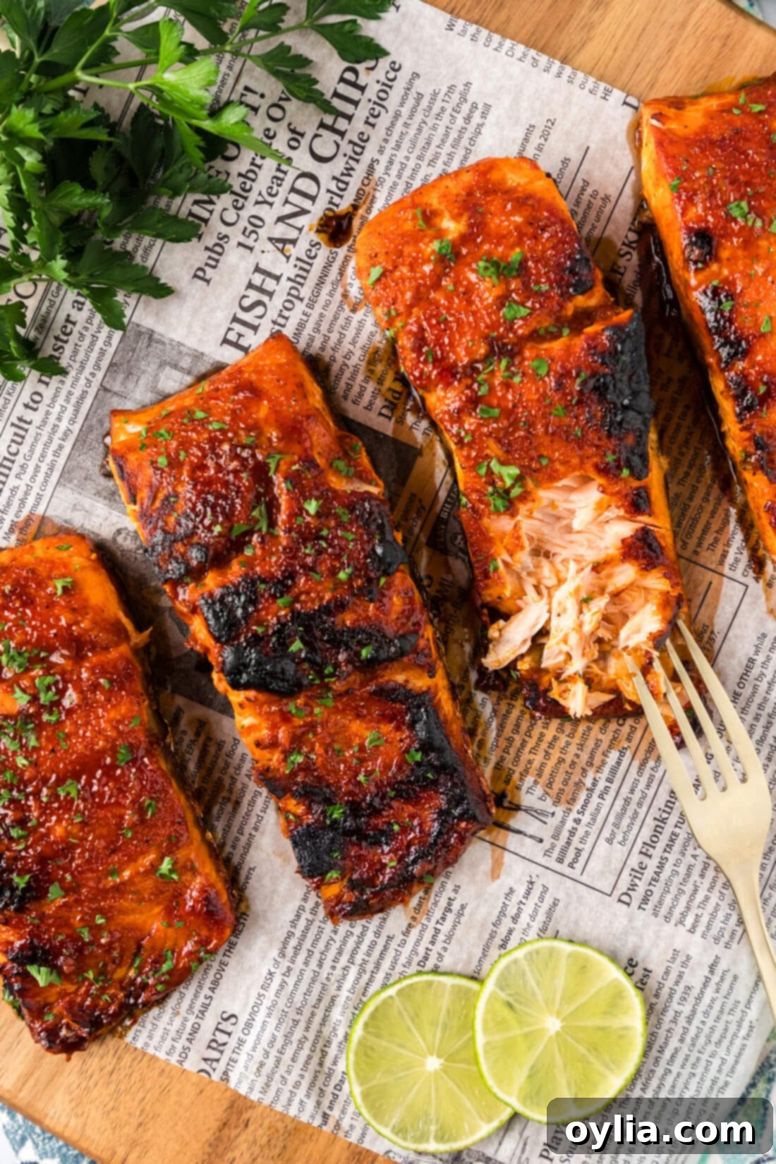 Fiery Salmon 2 Spicy Salmon filets on parchment with one filet broken up with a fork
