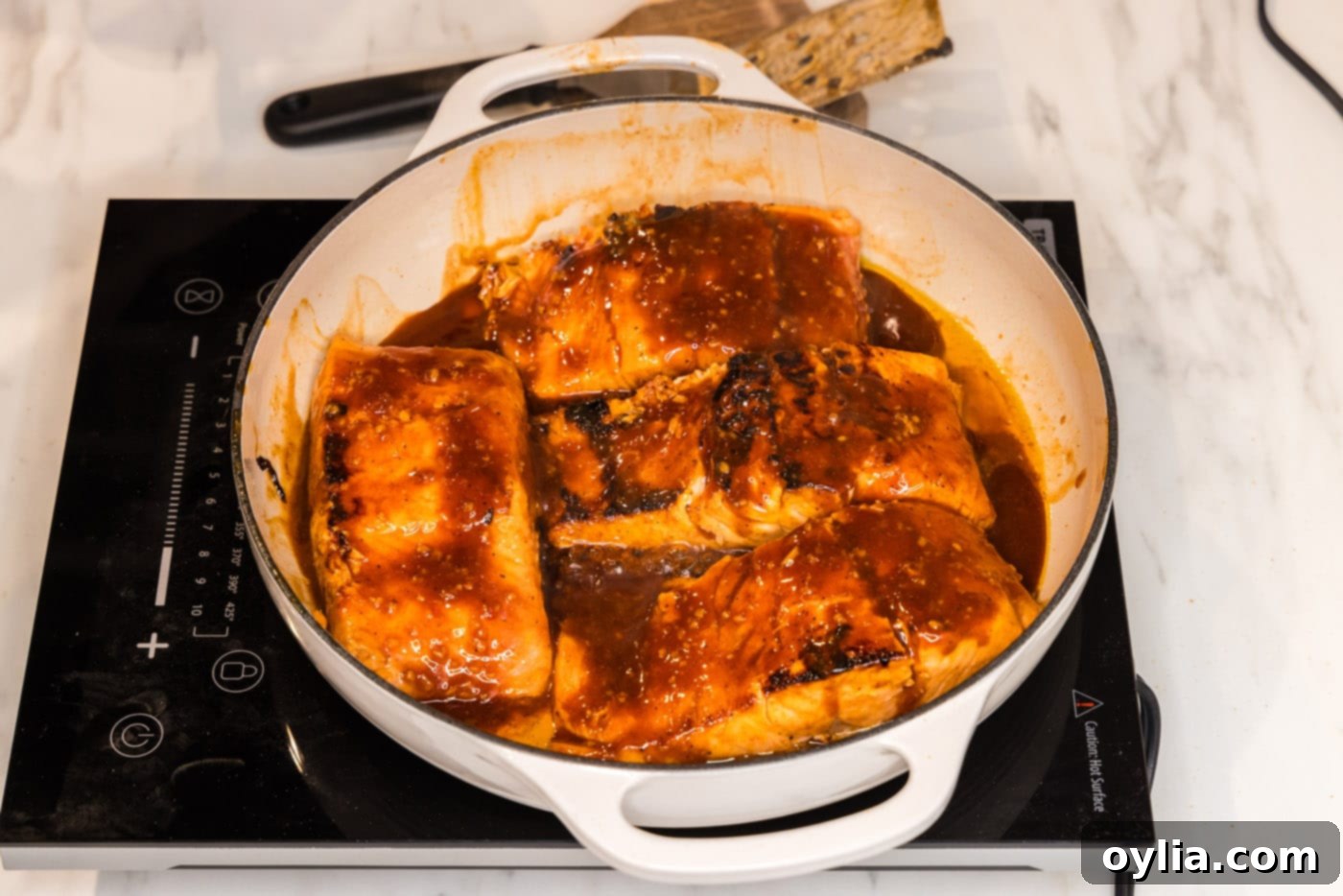 baked salmon filets in a skillet with spicy marinde