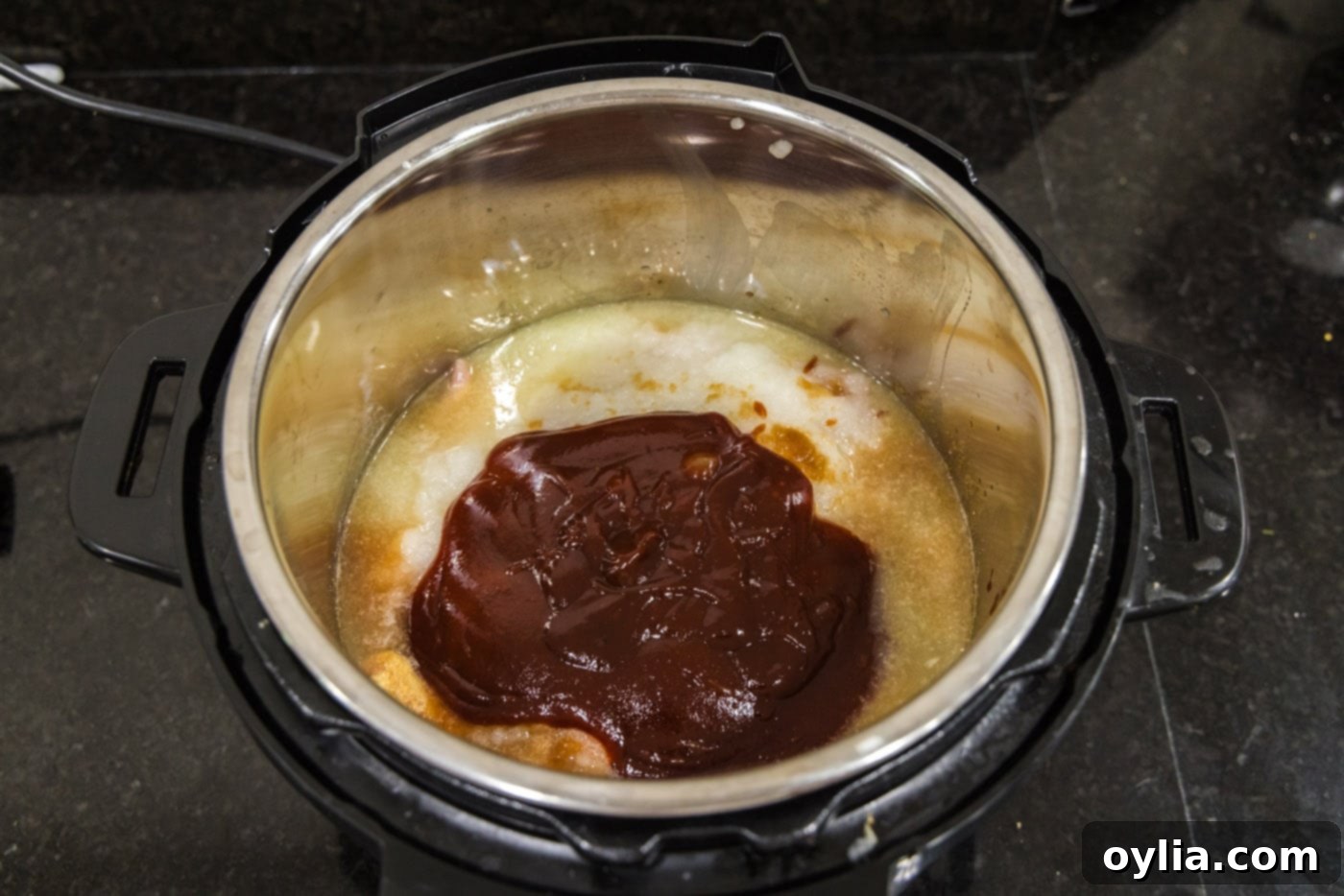 Barbecue sauce added on top of the chicken and spice mixture in the Instant Pot.