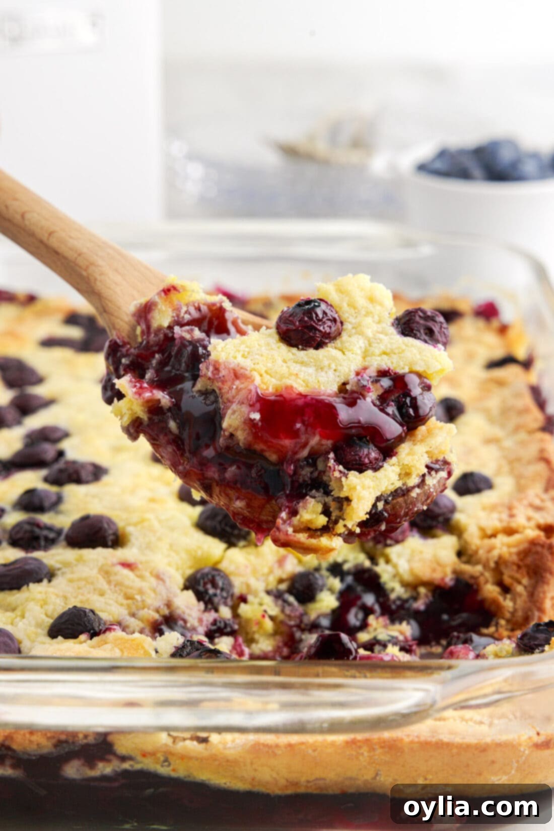 Spoonful of Blueberry Dump Cake being lifted out of the pan