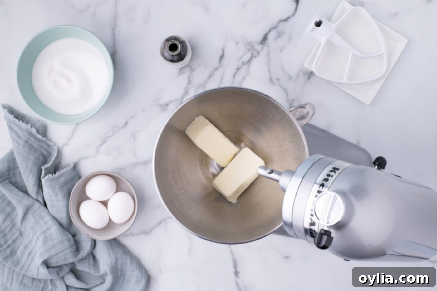Beating room temperature butter in a stand mixer bowl until light and fluffy
