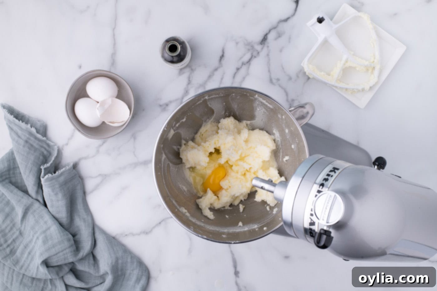 Eggs being beaten into the creamed butter and sugar mixture
