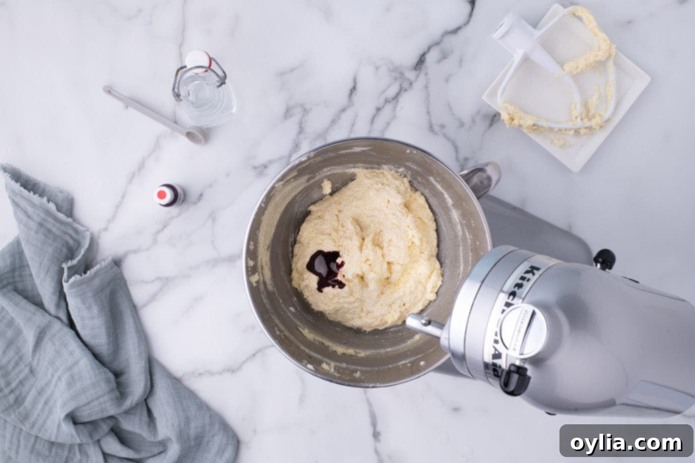 Adding red food coloring and vinegar to the red velvet cake batter ingredients