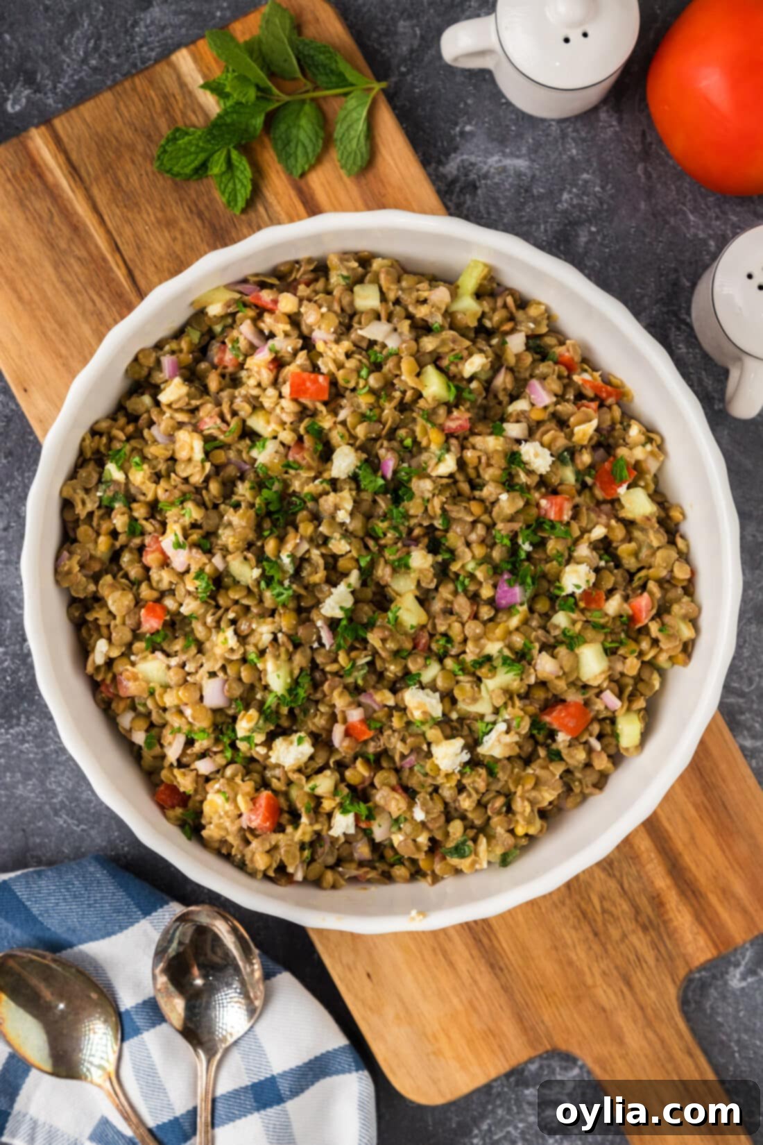 Lentil Salad in a bowl resting on a wooden platter, garnished with fresh mint.