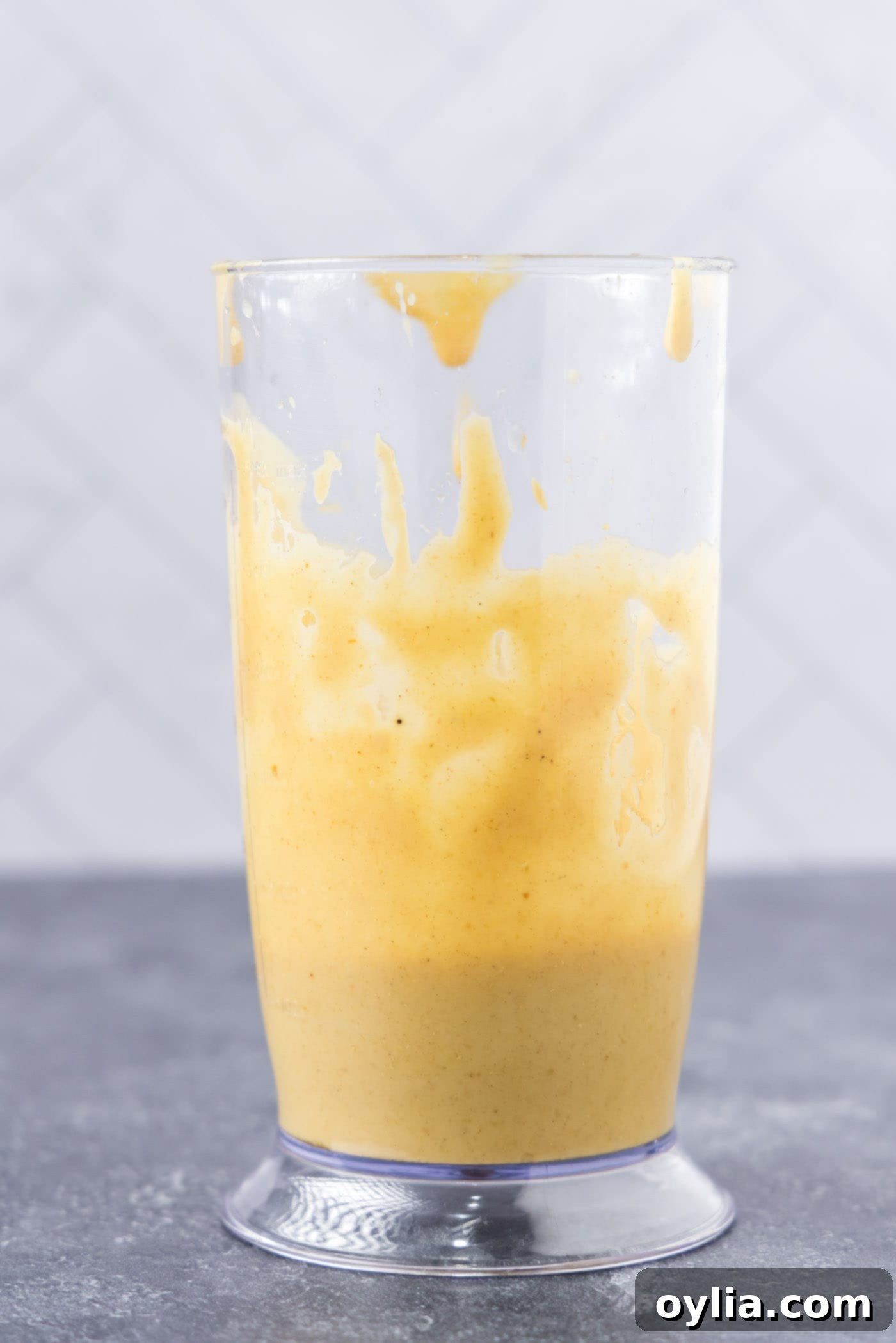 A close-up of the smooth, emulsified easy lentil salad dressing in a glass container.