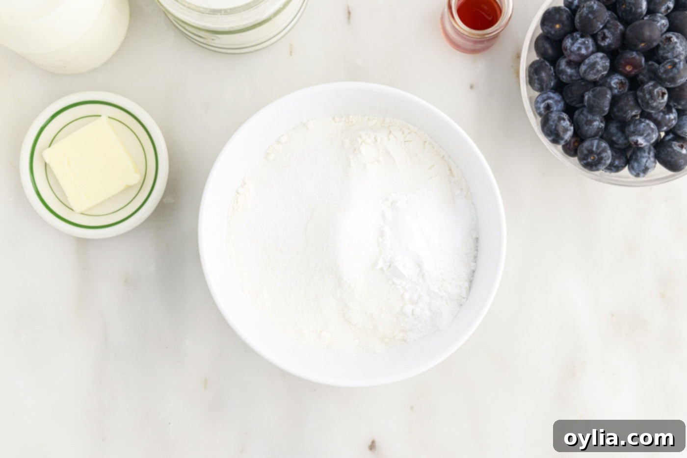 Dry ingredients for pancakes (flour, sugar, baking soda, baking powder, salt) mixed in a bowl.